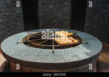 Leckeres Fleisch, gegrillt bei vulkanischer Hitze, Timanfaya-Nationalpark, Kanarische Inseln, Spanien Stockfoto