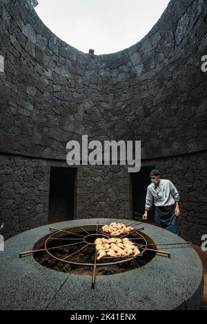 Timanfaya-Nationalpark, Spanien - 24. April 2022: Kochen Sie das Grillhähnchen bei vulkanischer Hitze im Restaurant El Diablo Stockfoto