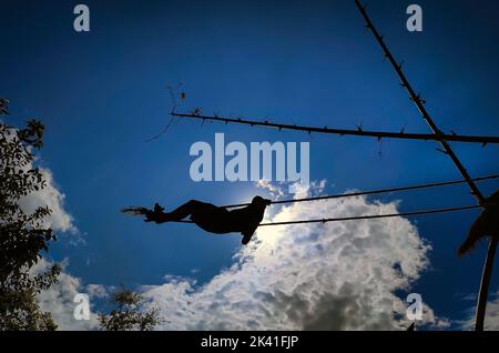 29. September 2022, Kathmandu, Bagmati, Nepal: Ein Junge wird beim traditionellen Swing anlässlich des Dashain-Festivals in Kathmandu, Nepal, am 29. September 2022 in Silhouetten gesetzt. (Bild: © Sunil Sharma/ZUMA Press Wire) Stockfoto