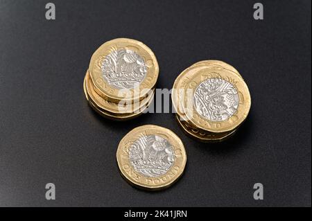Britische 1-Pfund-Münzen in GBP Währung Geld auf schwarzem Hintergrund Stockfoto