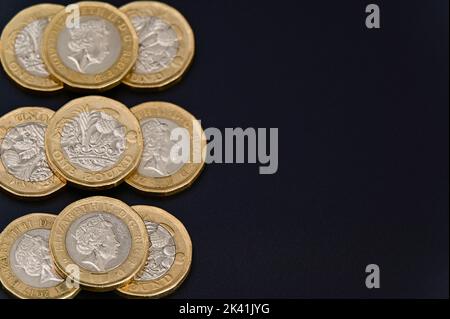 Britische 1-Pfund-Münzen in GBP Währung Geld auf schwarzem Hintergrund Stockfoto