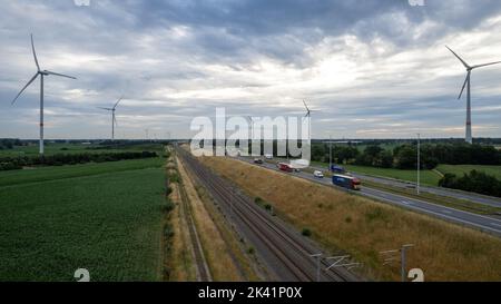 Brecht, Belgien, 6.. Juli 2022, Panorama-Drohnenansicht von Windpark oder Windpark, mit hohen Windkraftanlagen zur Stromerzeugung mit der Autobahn mit wenigen Autos und Eisenbahn daneben, in der Nähe der Ausfahrt von Brecht in Belgien, Europa. Hochwertige Fotos Stockfoto