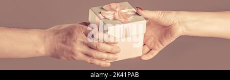 Frau Hände halten Geschenk. Geschenkbox in der Hand, Überraschung und Urlaubskonzept. Mann Hände halten Valentinstag Geschenk Stockfoto