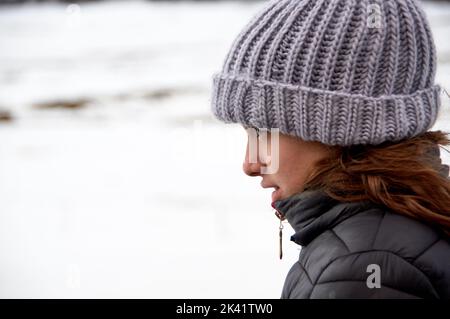 Porträt des Profils einer jungen Frau im Winter. Stockfoto