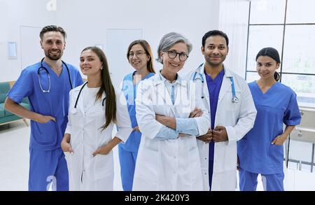 Selbstbewusste Ärzte und Krankenschwestern im modernen Krankenhaus. Medizinische Teamarbeit, internationale Ärztegruppe Stockfoto