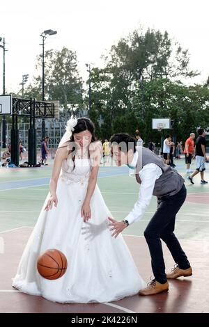 Braut und Bräutigam spielen Basketball Stockfoto