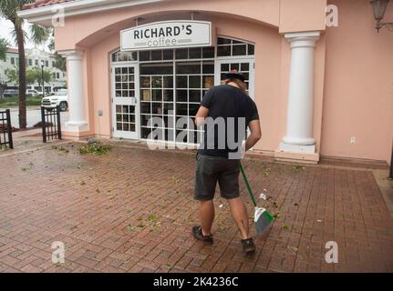 Winter Haven, Florida, USA. 29. September 2022. 29. September 2022, Winter Haven, Florida: Mitarbeiter von Richard's Coffee in der Innenstadt von Winter Haven, Florida, fegt nach dem Unwetter Ian Unrat. (Bild: © Dominic Gwinn/ZUMA Press Wire) Stockfoto