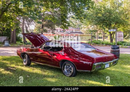 FLINT, MI/USA - 22. JUNI 2019: Ein 1968 Pontiac GTO-Auto und Parker Carousel, Sloan Museum Auto Fair, Crossroads Village, in der Nähe von Flint, Michigan. Stockfoto