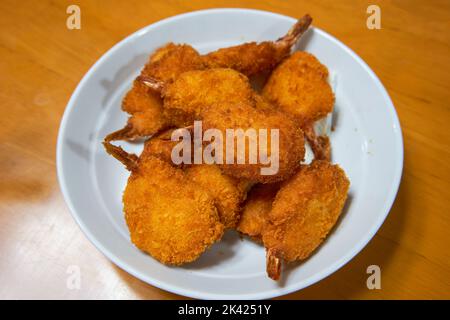 Ein Teller mit goldknusprigen gebratenen Schmetterlingsgarnelen Stockfoto