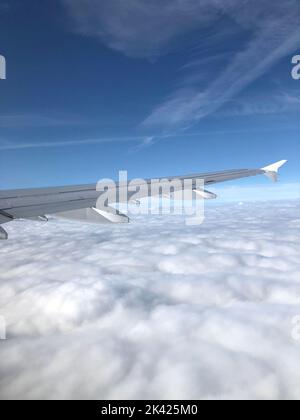 Wolkiger blauer Himmel und Detail der Flugzeugklappe (Flügel). Flugzeugdetails. Wunderschöner Himmel. Transport Stockfoto