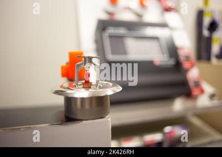Feueralarm und Scheinsprinkleranlage, die an einer weißen Wand befestigt ist, die für Schulungen verwendet wird Stockfoto