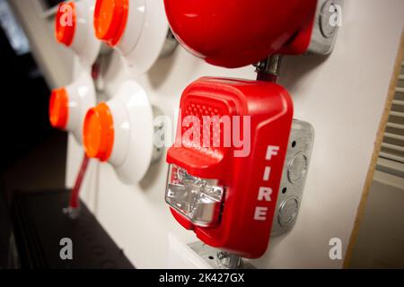 Feueralarm und Scheinsprinkleranlage, die an einer weißen Wand befestigt ist, die für Schulungen verwendet wird Stockfoto