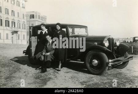 Mann und zwei Frauen mit einem alten Bianchi S8 Auto, Italien 1930s Stockfoto