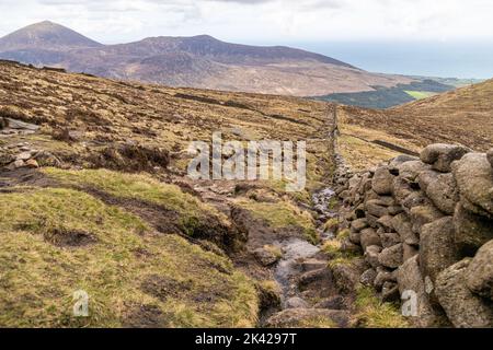 Eine Steinmauer, die durch die Mourne Mountains in Nordirland, Großbritannien, verläuft Stockfoto