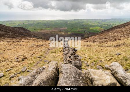 Eine Steinmauer, die durch die Mourne Mountains in Nordirland, Großbritannien, verläuft Stockfoto