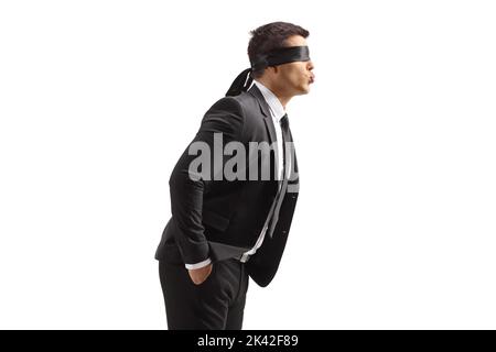 Profilaufnahme eines jungen Mannes in einem Anzug mit Augenbinde, die einen Kuss auf weißem Hintergrund abgeblasen hat Stockfoto