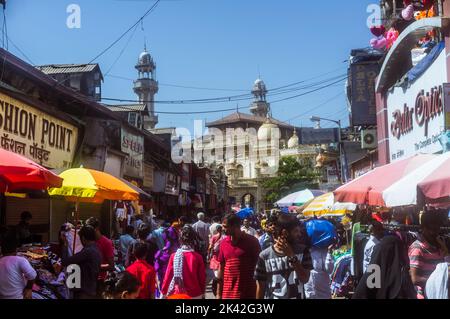 Mumbai, Maharashtra, Indien : auf dem Mangaldas-Markt in der Nachbarschaft von Kalbadevi kaufen die Menschen ein. Jama Masjid Moschee im Hintergrund. Stockfoto