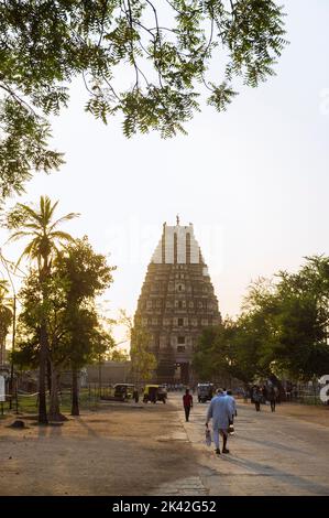 Hampi, Karnataka, Indien: Ein Mann geht bei Sonnenuntergang in Richtung des Sree Virupaksha Tempels aus dem 7.. Jahrhundert. Es wird angenommen, dass es seit seiner Einführung ununterbrochen funktioniert Stockfoto