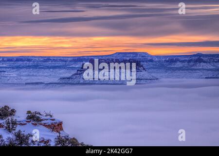 North Point und die Orange Cliffs erheben sich im Green River Basin im Canyonlands National Park, Utah, über den Nebel. Blick vom Candlestick Tower Stockfoto