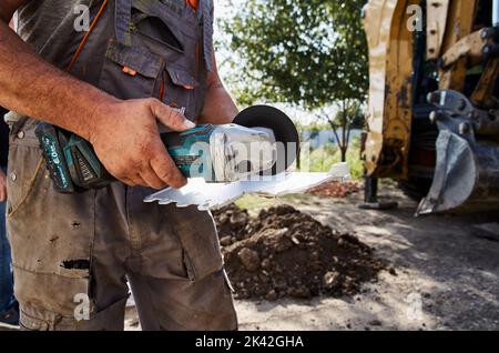 Arbeiter schneiden mit Arbeitswerkzeug Stockfoto