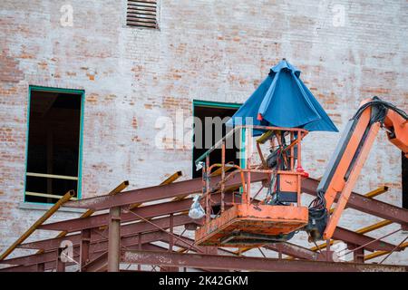 Leerer Kirschenpflücker mit gefaltetem Regenschirm auf der Baustelle in New Orleans, LA, USA Stockfoto