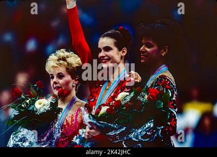 Katarina Witt (DDR) Goldmedaillengewinnerin und Olympiasiegerin mit Elizabeth Manley (CAN)-L- Silbermedaillengewinnerin und Bronzemedaillengewinnerin Debi Thomas (USA) beim Damen-Eiskunstlauf bei den Olympischen Winterspielen 1988. Stockfoto