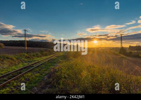 Alte nicht elektrifizierte Eisenbahnstrecke in der Nähe von Rakovnik Stadt in Sonnenuntergang Farbe Abend Stockfoto