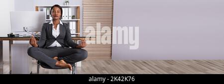 Afrikanische Geschäftsfrau Yoga Meditation im Büro Stockfoto