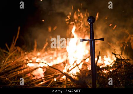 Nahaufnahme des Tempelschwertes, das durch Feuer auf dem Boden liegt Stockfoto