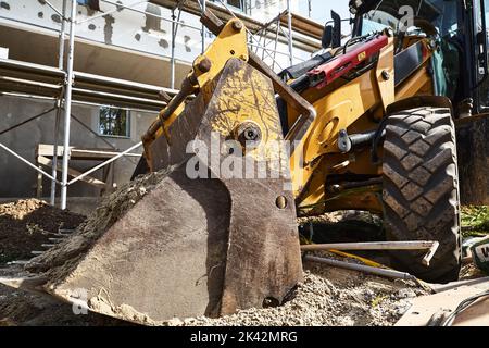 Bulldozer vorne Teil Details. Gebäudekonstruktion im Hintergrund Stockfoto