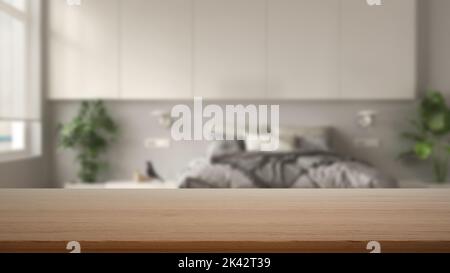 Leerer Holztisch, Schreibtisch oder Regal mit verschwommenem Blick auf das moderne, weiße Schlafzimmer, Bett mit Federdecke, Beistelltischen und Topfpflanzen, Kleiderschrank, minimalistischer Schrank Stockfoto