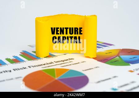 Geschäftskonzept. Vor dem Hintergrund von Grafiken und Diagrammen, eine gelbe Papierplatte mit der Aufschrift - Venture Capital Stockfoto