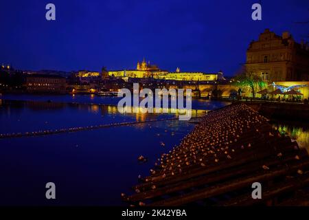 Die Nachtansicht auf hölzernen Eisbrechern mit sleaping seaguls auf Moldau mit hellen Hradcany Bezirk auf Hintergrund in Prag, Tschechische Republik Stockfoto