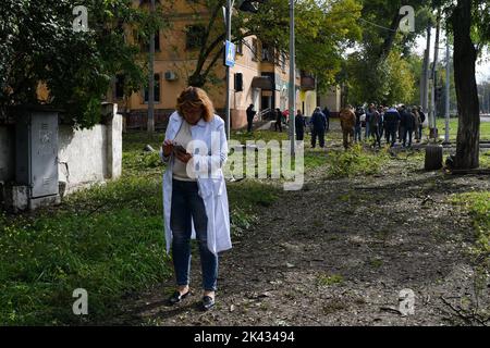 Kramatorsk, Donezk, Ukraine. 29. September 2022. Ein Arzt eines Krankenwagens und Menschen werden in der Nähe eines Krater gesehen, der durch eine Explosion nach einem russischen Angriff in Kramatorsk entstanden ist. Wolodymyr Zelenskyy, der Präsident der Ukraine, hat den Nationalen Sicherheits- und Verteidigungsrat aufgefordert, am Freitag, dem 30. September, eine dringende Sitzung abzuhalten. Russland plante, am Freitag, dem 30. September, mehr von der Ukraine zu annektieren, um den siebenmonatigen Krieg zu eskalieren, der mit Sicherheit den Kreml weiter isolieren, ihn internationaler bestrafen und der Ukraine zusätzliche militärische, politische und wirtschaftliche Unterstützung bringen würde. (Bild: © A Stockfoto