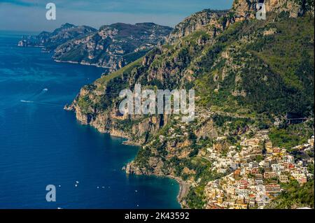 Luftaufnahme von Positano in Italien mit einem spektakulären Hintergrund aus blauen Wolken und bunten Häusern an der Küste Stockfoto