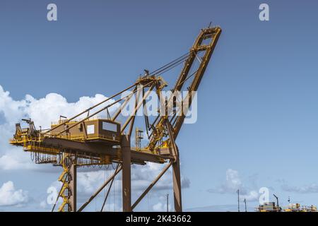 Nahaufnahme eines schweren, riesigen Hafenkrans vor einer wunderschönen Skyscape, mit einer großen Kabine, vielen Treppen, Kabeln und Durchgängen mit Zäunen auf der ITS Stockfoto