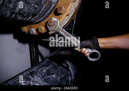 Arbeiter, der Wasserleitung im technischen Tunnel installiert, Nahaufnahme Stockfoto