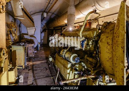 Alter rostiger Dieselgenerator im verlassenen sowjetischen Bunker. Stockfoto