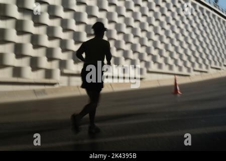 Izmir, Türkei - 11. September 2022: Silhouette einer Lauffrau, die zum 100.. Jahrestag der Befreiung Izmirs in der Türkei in Izmir läuft. Stockfoto