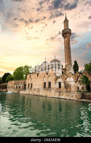 Balikligol (der Fischsee auf Englisch) in Sanliurfa, Türkei, mit Sonnenuntergang am Himmel. Der historische Pool von Abraham oder der Pool des Heiligen Fischs in der Stadt Urfa, Stockfoto