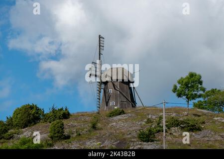 Schwedische Landschaft mit Ruine der hölzernen Windmühle Stockfoto