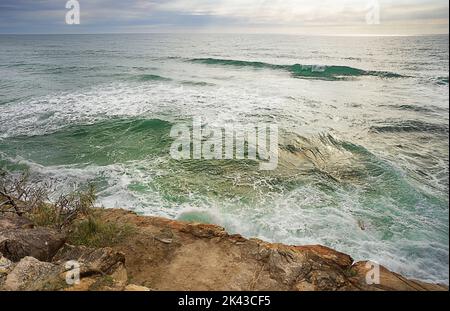 Turbulentes Wasser, das bei Flut über Felsen bricht, entlang einer felsigen Küste an der Sunshine Coast, Queensland. Stockfoto