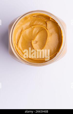 Bild eines Glases mit Erdnussbutter auf weißer Oberfläche Stockfoto