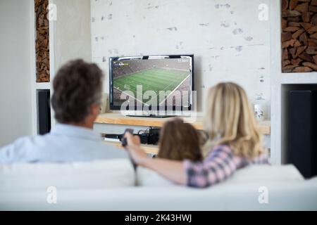 Kaukasische Familie schaut beim Fußballspiel auf dem Bildschirm fern Stockfoto