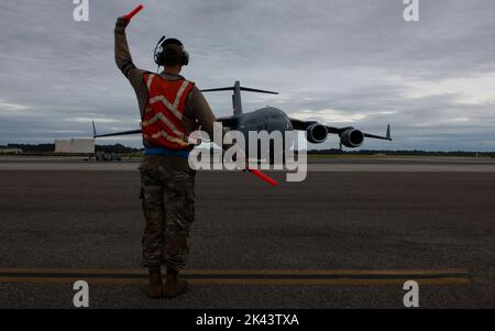 Gemeinsame Basis Charleston, Florida, USA. 29. September 2022. US Air Force Airman 1. Class Justin Carrizales, 437. Aircraft Maintenance Squadron Crew Chief, Marshals A C-17 Globemaster III während der Umzugsoperationen in Vorbereitung auf Tropical Storm Ian auf der Joint Base Charleston, South Carolina, 29. September 2022. Die Basis verlegt routinemäßig Flugzeuge vor extremen Wetterbedingungen, um die schnelle globale Mobilitätsmission fortzusetzen und mögliche Schäden zu vermeiden. Quelle: U.S. Air Force/ZUMA Press Wire Service/ZUMAPRESS.com/Alamy Live News Stockfoto