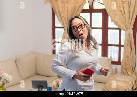 Ältere Frau, die zu Hause Musik hört und tanzt Stockfoto