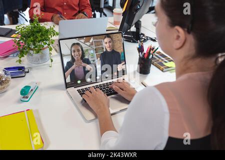 Kaukasische Geschäftsfrau mit Videoanruf mit Kollegen. Globales Business- und digitales Schnittstellenkonzept, digitales Composite-Bild. Stockfoto