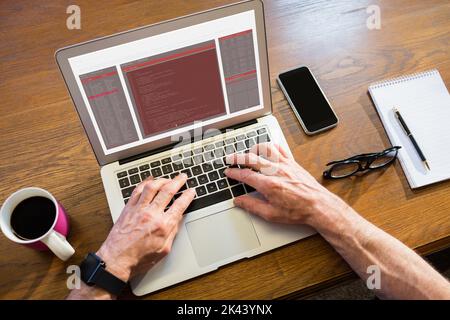 Geschäftsmann, der im Büro einen Laptop benutzt Stockfoto