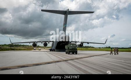 Mitglieder der US-Armee bereiten sich darauf vor, während der Übung GOLDEN BEE auf der Andersen Air Force Base, Guam, 26. September 2022, ein High Mobility Artillery Rocket System auf eine US Air Force C-17 Globemaster III zu laden, die der Dover Air Force Base, Delaware, zugewiesen wurde. Übung GOLDEN BEE ist eine gemeinsame Bereitschaftsübung unter der Leitung des Air Mobility Command und wurde entwickelt, um Trainingsintegration zu bieten und strategische und operative Ziele zur Unterstützung von Initiativen zur Bekämpfung von agilen Beschäftigungsmaßnahmen im Verantwortungsbereich des Indo-Pazifik-Raums zu Proben. (USA Luftwaffe Foto von 1. LT. Jade Watkins) Stockfoto