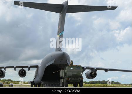 Mitglieder der US-Armee bereiten sich darauf vor, während der Übung GOLDEN BEE auf der Andersen Air Force Base, Guam, 26. September 2022, ein High Mobility Artillery Rocket System auf eine US Air Force C-17 Globemaster III zu laden, die der Dover Air Force Base, Delaware, zugewiesen wurde. Übung GOLDEN BEE ist eine gemeinsame Übung zur Bereitschaft, die die Integration von Schulungen und die Einarbeitung strategischer und operativer Ziele zur Unterstützung von Initiativen zur agilen Bekämpfung von Beschäftigung im Verantwortungsbereich des Indo-Pazifik-Raums ermöglicht. (USA Foto der Luftwaffe von Staff Sgt. Aubree Owens) Stockfoto